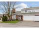 Charming townhome featuring a red brick facade, bay window, attached garage, and well-maintained landscaping at 1457 Dominion Dr, Zionsville, IN 46077