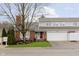 Charming townhome featuring a red brick facade, bay window, attached garage, and well-maintained landscaping at 1457 Dominion Dr, Zionsville, IN 46077