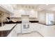 Bright kitchen featuring white cabinetry, updated appliances, sleek black countertops, and tiled flooring at 1457 Dominion Dr, Zionsville, IN 46077