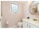 Cozy powder room with patterned wallpaper, a decorative mirror, and white fixtures at 1457 Dominion Dr, Zionsville, IN 46077