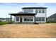 The rear exterior of the home with a covered porch is newly landscaped at 15871 Vitalize Run, Fishers, IN 46040