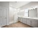 Well-lit bathroom featuring a glass-enclosed shower and dual sink vanity at 15871 Vitalize Run, Fishers, IN 46040