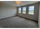 Bedroom with three windows allowing natural light and neutral colored carpet at 15871 Vitalize Run, Fishers, IN 46040