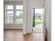 Bright entryway featuring hardwood floors, large windows, and a view of the home across the street at 15871 Vitalize Run, Fishers, IN 46040
