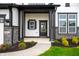 Inviting front porch with decorative stone accents, manicured flower beds, and an elegant front door at 15871 Vitalize Run, Fishers, IN 46040