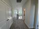 A carpeted hallway with white trim and doors with a staircase and railing at 15871 Vitalize Run, Fishers, IN 46040