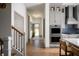 Bright hallway featuring hardwood floors, a staircase, and entry to the modern kitchen at 15871 Vitalize Run, Fishers, IN 46040