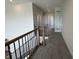 Hallway overlooking stairway with metal railing and carpet at 15871 Vitalize Run, Fishers, IN 46040