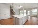 Large kitchen island with ample counter space, ideal for cooking and entertaining with an adjacent staircase at 15871 Vitalize Run, Fishers, IN 46040