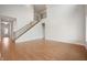 Spacious living room with hardwood floors, high ceilings, and a staircase with dark metal railing at 15871 Vitalize Run, Fishers, IN 46040