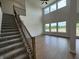 Bright living room featuring hardwood floors, staircase, and abundant natural light at 15871 Vitalize Run, Fishers, IN 46040