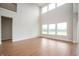 Open living room with hardwood floors, high ceilings, and large windows offering beautiful views at 15871 Vitalize Run, Fishers, IN 46040