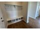 A mudroom with built in bench and coat hooks with shelving above, and wood flooring at 15871 Vitalize Run, Fishers, IN 46040