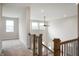 Upstairs hallway view featuring wood and metal railing, a modern ceiling fan, and natural light at 15871 Vitalize Run, Fishers, IN 46040