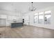 Bright kitchen featuring white cabinets, gray island, modern lighting, and hardwood flooring at 17364 Pinellas Ave, Westfield, IN 46074