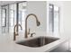 Close up of stainless steel sink and modern gold fixtures set in a stylish kitchen with natural light at 17364 Pinellas Ave, Westfield, IN 46074