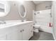 Bathroom featuring double sink vanity, oval mirrors, white tile tub, and grey vinyl floors at 1820 E Maryland St, Indianapolis, IN 46201