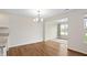 Empty dining area features hardwood floors and a view of the well-lit living room with a large window at 19568 Astoria Ave, Sheridan, IN 46069