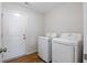 Clean laundry room featuring modern white washer and dryer units with wood-look laminate flooring at 19568 Astoria Ave, Sheridan, IN 46069