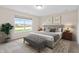 Well-staged main bedroom with a large window view, decorative lamps, and soft, inviting colors at 19568 Astoria Ave, Sheridan, IN 46069