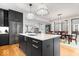 Open kitchen features dark cabinets, stainless steel appliances, island with seating, and adjoining dining area at 2026 Alvord St, Indianapolis, IN 46202