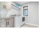 Efficient laundry room with modern washer and dryer, sleek cabinetry, and a well-lit window at 2026 Alvord St, Indianapolis, IN 46202