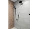 This contemporary shower design features contrasting geometric tile and a modern handheld shower head fixture at 2026 Alvord St, Indianapolis, IN 46202
