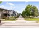 A quiet neighborhood street, a pedestrian walkway, colorful houses, and lush trees creating a pleasant residential scene at 2026 Alvord St, Indianapolis, IN 46202