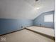 An attic with an accent wall, carpet, and a window at 208 S Conger St, , IN 47272