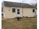 Small backyard with yellow siding, back door with small stoop, and minimal lawn at 2261 N Centennial St, Indianapolis, IN 46222
