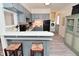 A well-lit kitchen with modern appliances, gray cabinets and a breakfast bar with two stools at 243 S 3Rd Ave, Beech Grove, IN 46107