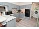 Bright kitchen featuring gray cabinets, a mosaic backsplash, modern appliances, and wood-look vinyl flooring at 243 S 3Rd Ave, Beech Grove, IN 46107