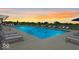 Community pool showcases lounge chairs, umbrellas, and a picturesque sunset backdrop at 2556 Lamar Dr, Whitestown, IN 46075
