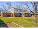 Large backyard featuring brick and siding home, basketball hoop, enclosed patio, and lush lawn at 2665 Chestnut St, Columbus, IN 47201