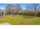 Expansive backyard with mature trees, green lawn, and a glimpse of the screened-in patio at 2665 Chestnut St, Columbus, IN 47201