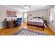Sunlit bedroom featuring hardwood floors, a classic bed frame, and a comfortable workspace at 2665 Chestnut St, Columbus, IN 47201