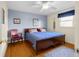 Bedroom featuring hardwood floors, a ceiling fan, and a window with blue curtains at 2665 Chestnut St, Columbus, IN 47201