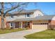 Classic two-story home with brick and vinyl siding, a well-manicured lawn, and an attached garage at 2665 Chestnut St, Columbus, IN 47201