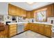 Well-lit kitchen with white countertops, stainless steel dishwasher, and wooden cabinetry at 2665 Chestnut St, Columbus, IN 47201