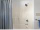 Shower featuring a shower head, curtain, and clean white tiles, offering a refreshing and functional space at 2665 Chestnut St, Columbus, IN 47201