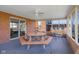 Enclosed sunroom boasts brick accents, ceiling fan, and a unique picnic table for dining and relaxing at 2665 Chestnut St, Columbus, IN 47201