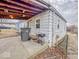 View of back exterior with concrete patio, grill, trash can, and some lawn equipment at 2959 N Lasalle St, Indianapolis, IN 46218