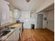 Traditional kitchen featuring wood-look flooring, white cabinets, and a double-basin sink at 2959 N Lasalle St, Indianapolis, IN 46218