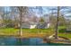 Lakefront property with manicured lawn, mature trees, and a charming home exterior offers a serene and picturesque setting at 3232 Beech Dr, Columbus, IN 47203