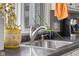 A close up view of a stainless steel kitchen sink with flowers and plants on a dark countertop at 3232 Beech Dr, Columbus, IN 47203