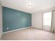 Bright bedroom with neutral carpet, soothing teal accent wall, and natural light from a window at 3328 Stoddard Pl, Indianapolis, IN 46217