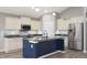 Modern kitchen features stainless steel appliances, a center island with a dark base, and sleek countertops at 3328 Stoddard Pl, Indianapolis, IN 46217