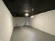 Finished basement featuring painted block walls, epoxy flooring, and a garage door at 3516 N Sherman Dr, Indianapolis, IN 46218