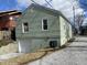 Exterior view of a home with a garage and green siding, complemented by a gravel driveway at 3516 N Sherman Dr, Indianapolis, IN 46218