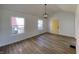 Bright living room with two windows, a modern light fixture, and a yellow entry door at 3516 N Sherman Dr, Indianapolis, IN 46218